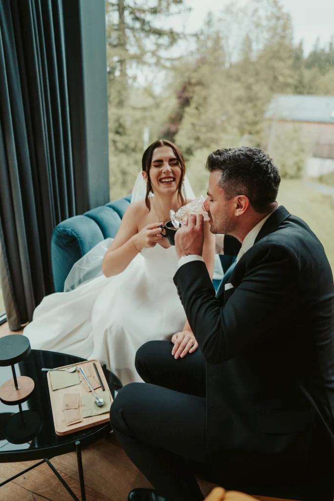 Recenze „Svatební focení – Eliška“ – přirozený moment novomanželů v interiéru u okna, smích a emoce během svatebního dne.