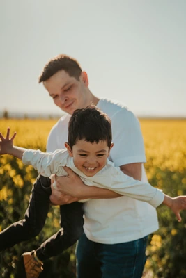 Tatínek nese syna na zádech během rodinného focení v přírodě