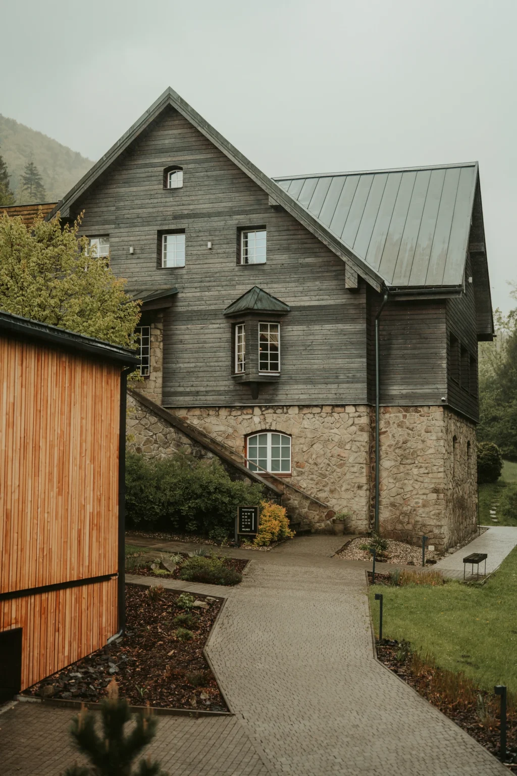 Kamenná budova Hotelu U Holubů po dešti