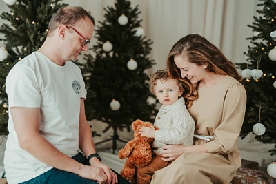 Alena se dívá na Noeho, Michal sedí vedle nich u vánočního stromku.